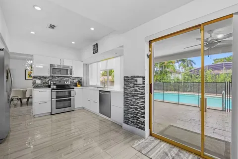 a kitchen with a refrigerator and a stove top oven