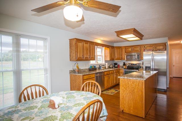 4086 Trinity Road Franklin, TN 37067 - Photo 6 of 20 a kitchen with stainless steel appliances granite countertop a kitchen island a stove a sink a dining table and chairs with wooden floor