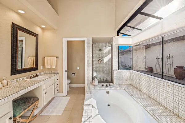 a bathroom with a tub sink and glass door