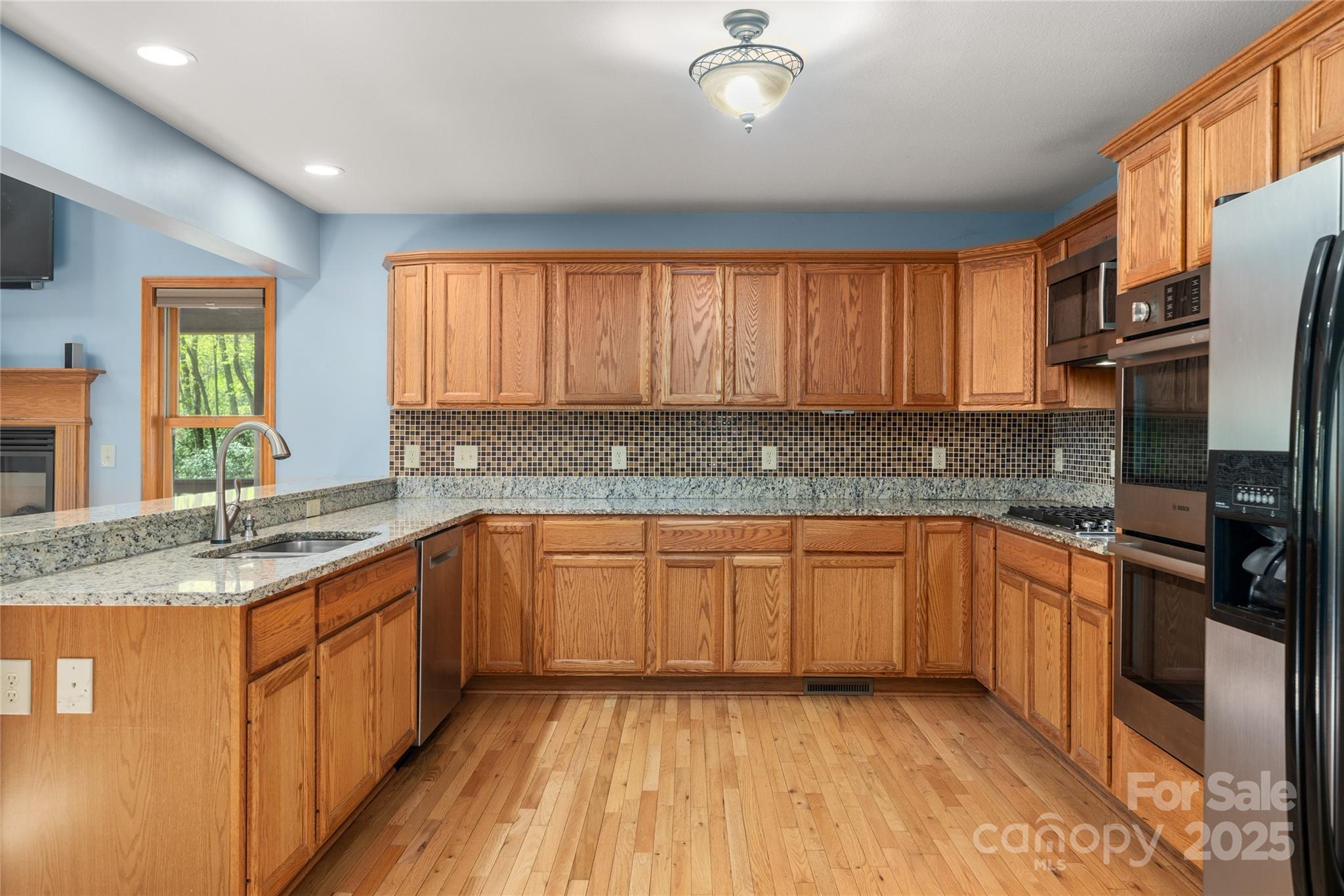 234 Deer Run Road Canton, NC 28716 - Photo 20 of 48 a kitchen with stainless steel appliances granite countertop a sink stove cabinets and wooden floor