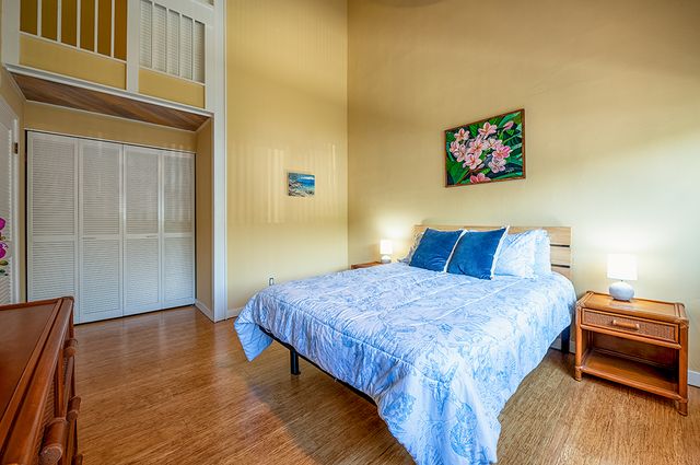 a bedroom with a bed and a dresser next to a window