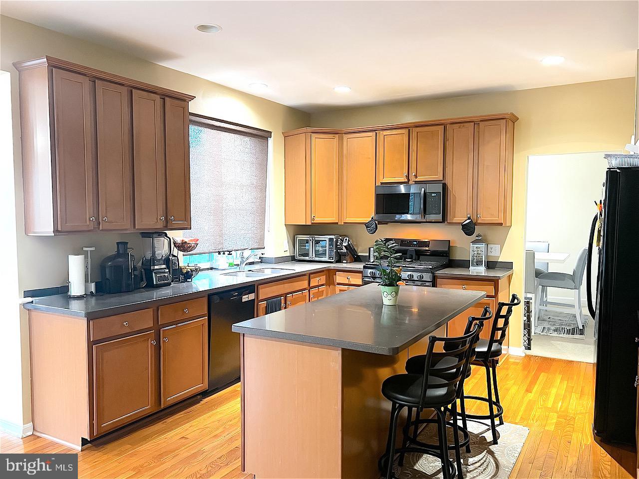 1649 Thorndale Road Breinigsville, PA 18031 - Photo 7 of 19 a kitchen with stainless steel appliances granite countertop a stove top oven a sink dishwasher a dining table and chairs with wooden floor