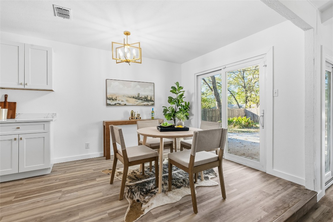 6710 Kings Point West Austin, TX 78723 - Photo 11 of 40 a dining room with furniture a window and wooden floor