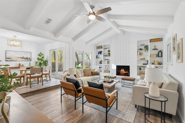 a living room with furniture a fireplace and a large window