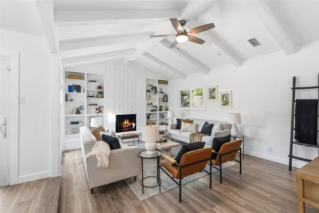 a living room with furniture a fireplace and a flat screen tv