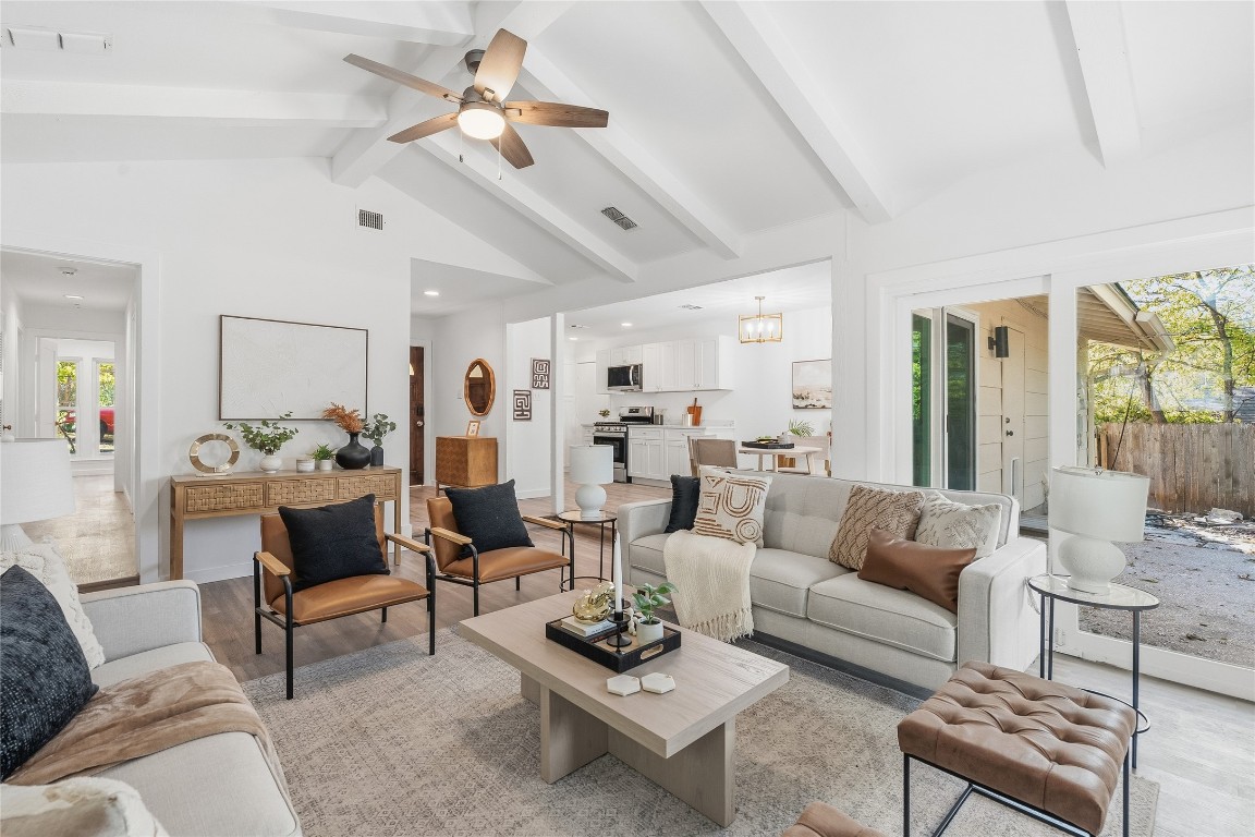 6710 Kings Point West Austin, TX 78723 - Photo 8 of 40 a living room with furniture a rug kitchen view and a chandelier