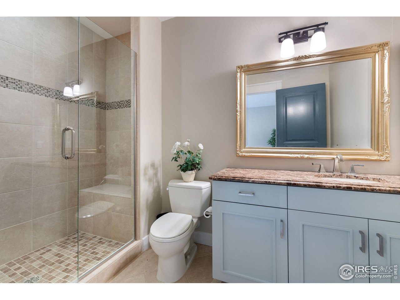 7205 Rustic Trail Boulder, CO 80301 - Photo 47 of 49 a bathroom with a toilet a sink a glass door a shower and a mirror