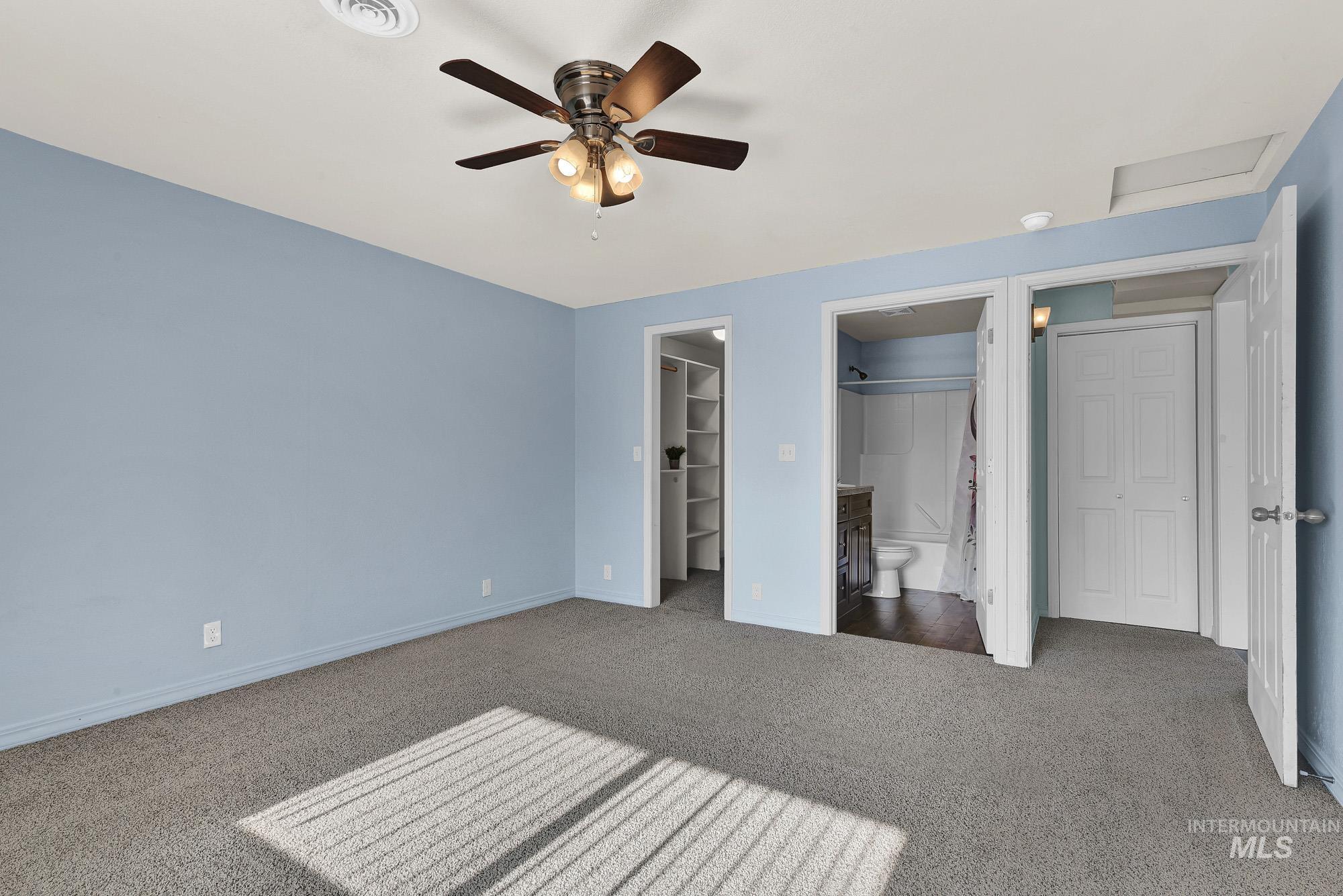 901 East 2nd Street South Middleton, ID 83644 - Photo 15 of 50 Primary bedroom suite with new carpet flooring, connected bathroom, ceiling fan, and a walk in closet