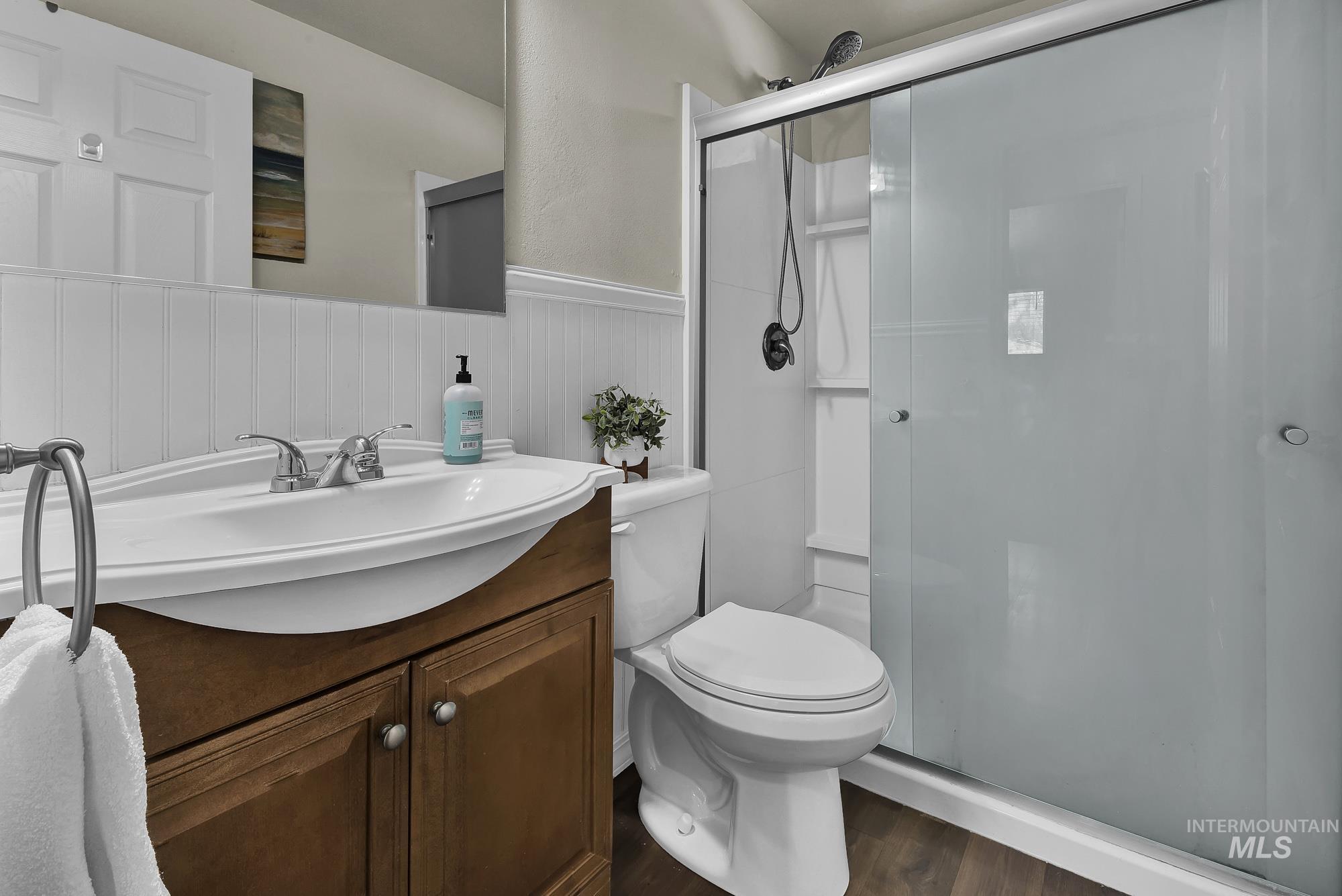 901 East 2nd Street South Middleton, ID 83644 - Photo 23 of 50 Bathroom featuring a wainscoted wall, vanity, a shower stall, and laminate wood like finished floors