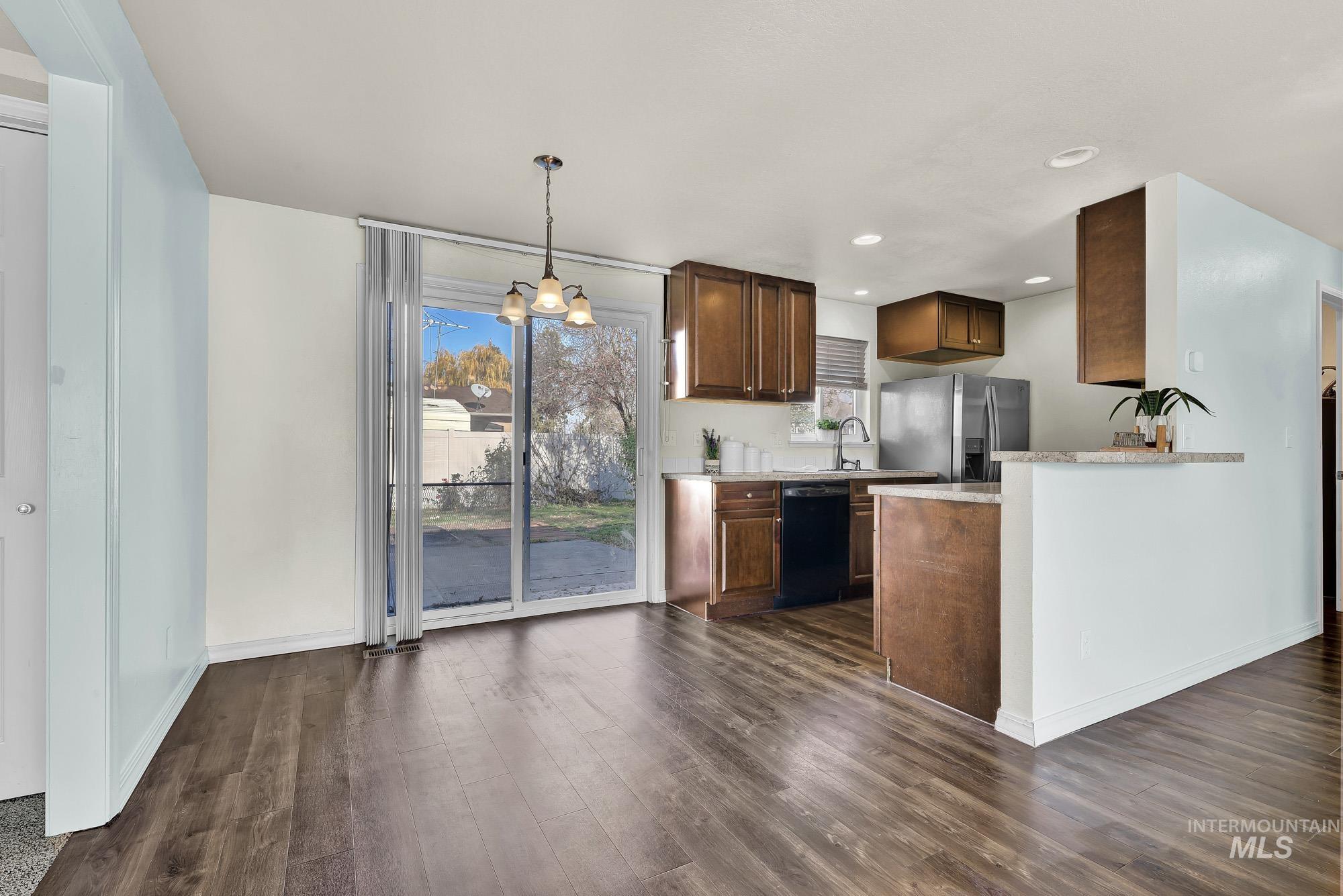 901 East 2nd Street South Middleton, ID 83644 - Photo 8 of 50 Kitchen featuring a chandelier, light laminate counters, stainless steel refrigerator with ice dispenser, laminate wood-style floors, and black dishwasher