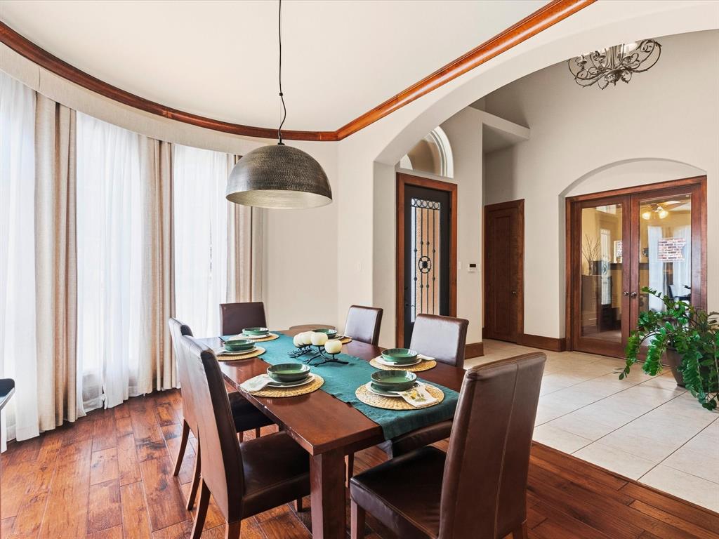 1615 Roma Lane Allen, TX 75013 - Photo 5 of 36 Dining area featuring wood-finish flooring, a contemporary dome pendant light, and a curved window wall with sheer drapes