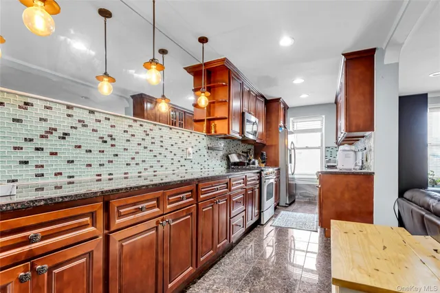 a kitchen with stainless steel appliances granite countertop a stove a sink and a refrigerator