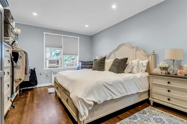 a bedroom with a bed and a flat tv screen on the dresser