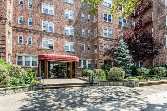 a front view of a multi story building with yard