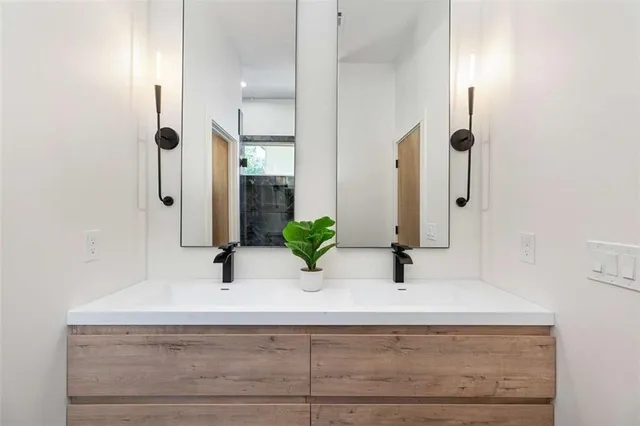 a bathroom with double vanity sink a mirror and shower