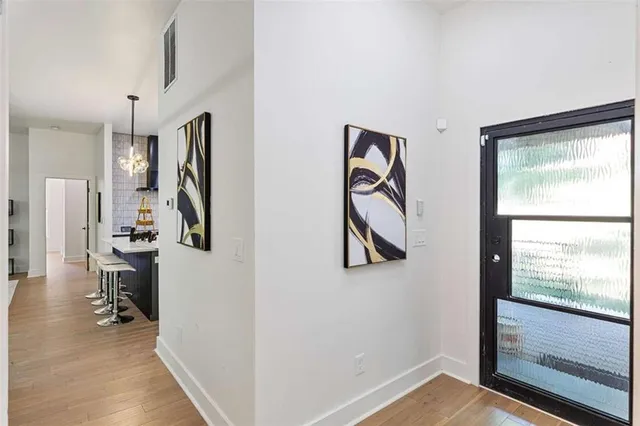 a view of a hallway with a large window and a refrigerator