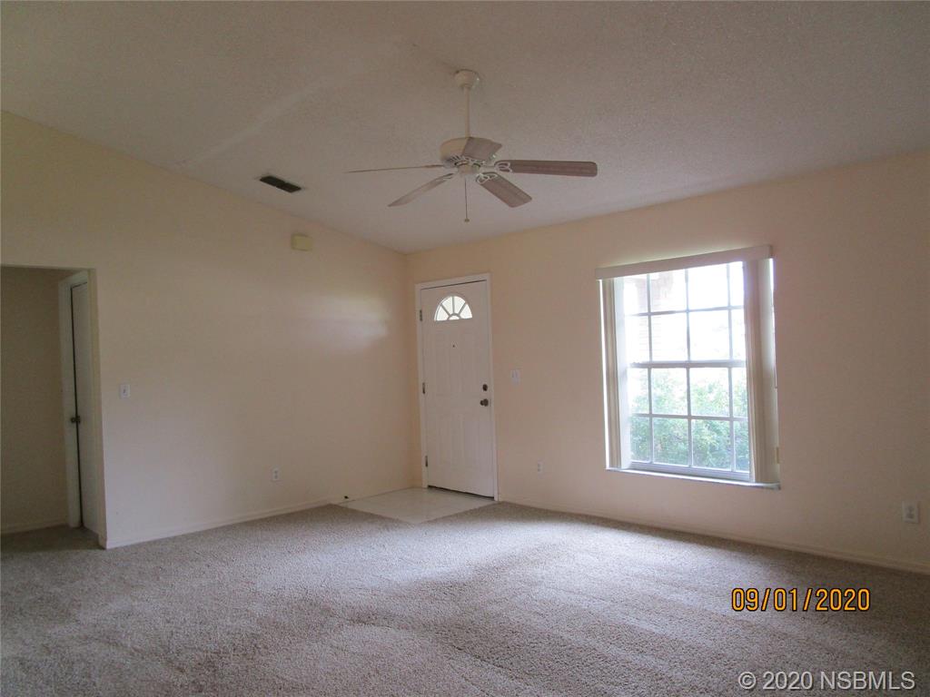 508 Sandpiper Court Edgewater, FL 32141 - Photo 2 of 10 an empty room with windows and fan