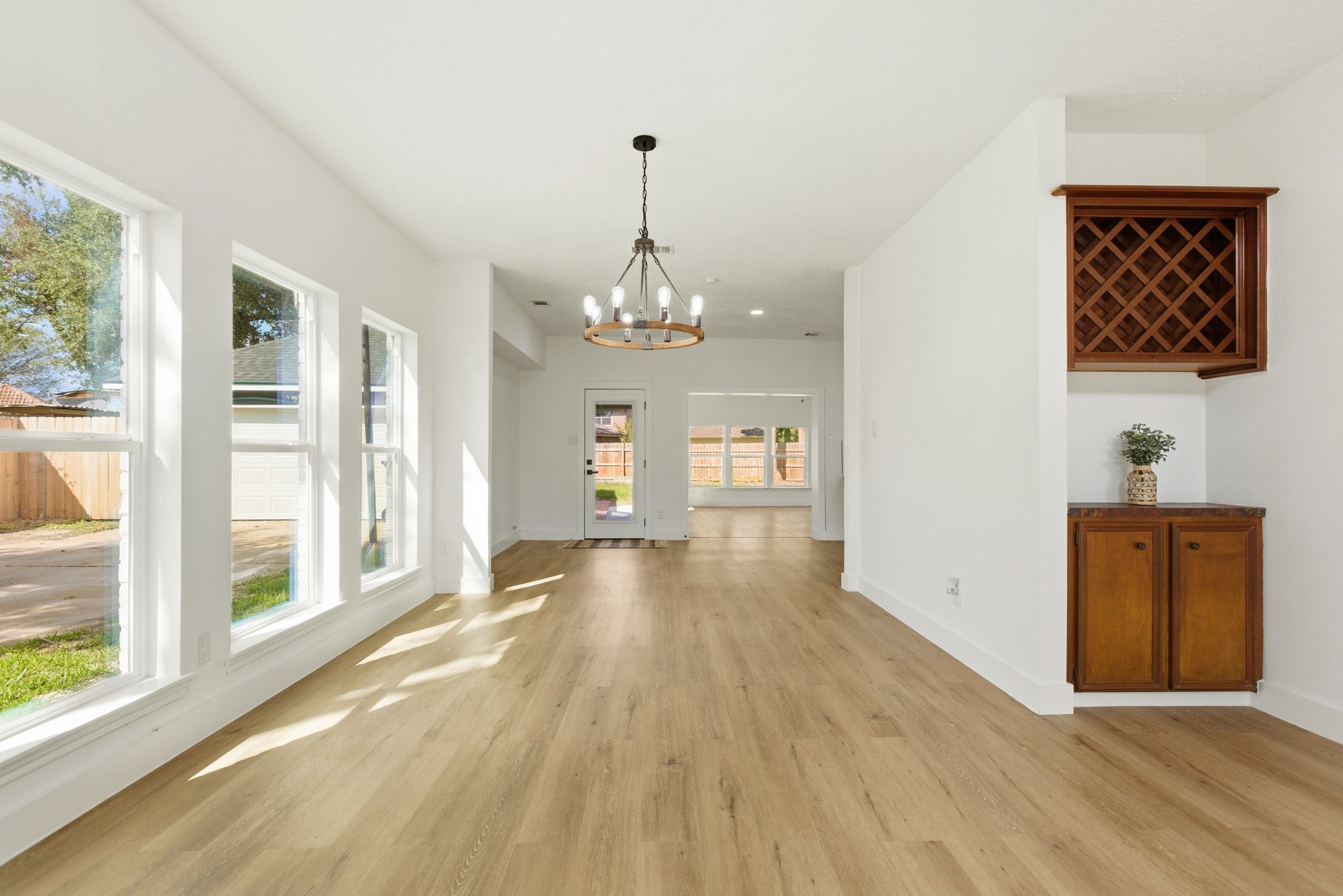 7338 San Ramon Drive Houston, TX 77083 - Photo 11 of 38 a view of a hallway with wooden floor and a chandelier