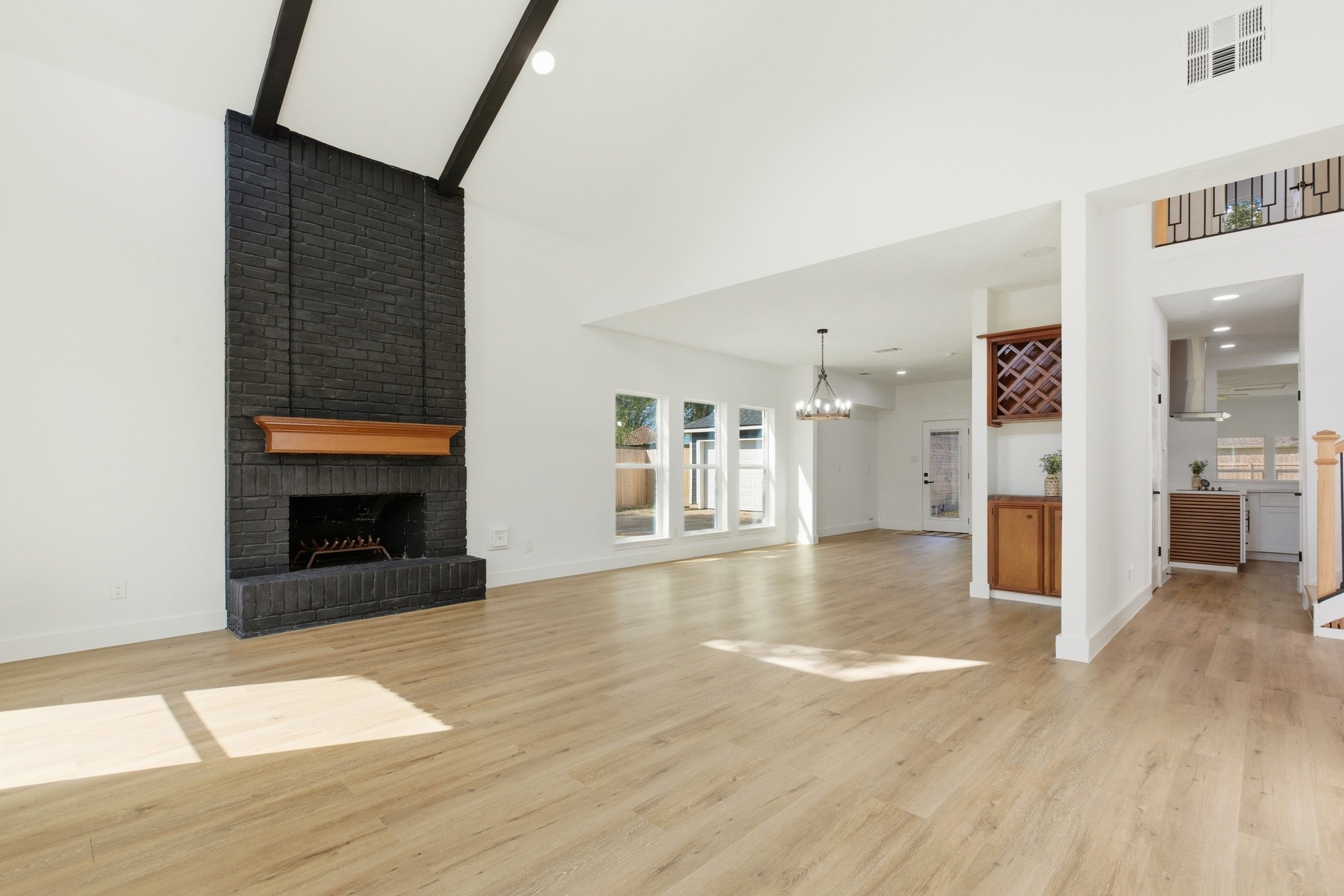 7338 San Ramon Drive Houston, TX 77083 - Photo 9 of 38 a view of an empty room with wooden floor and a kitchen