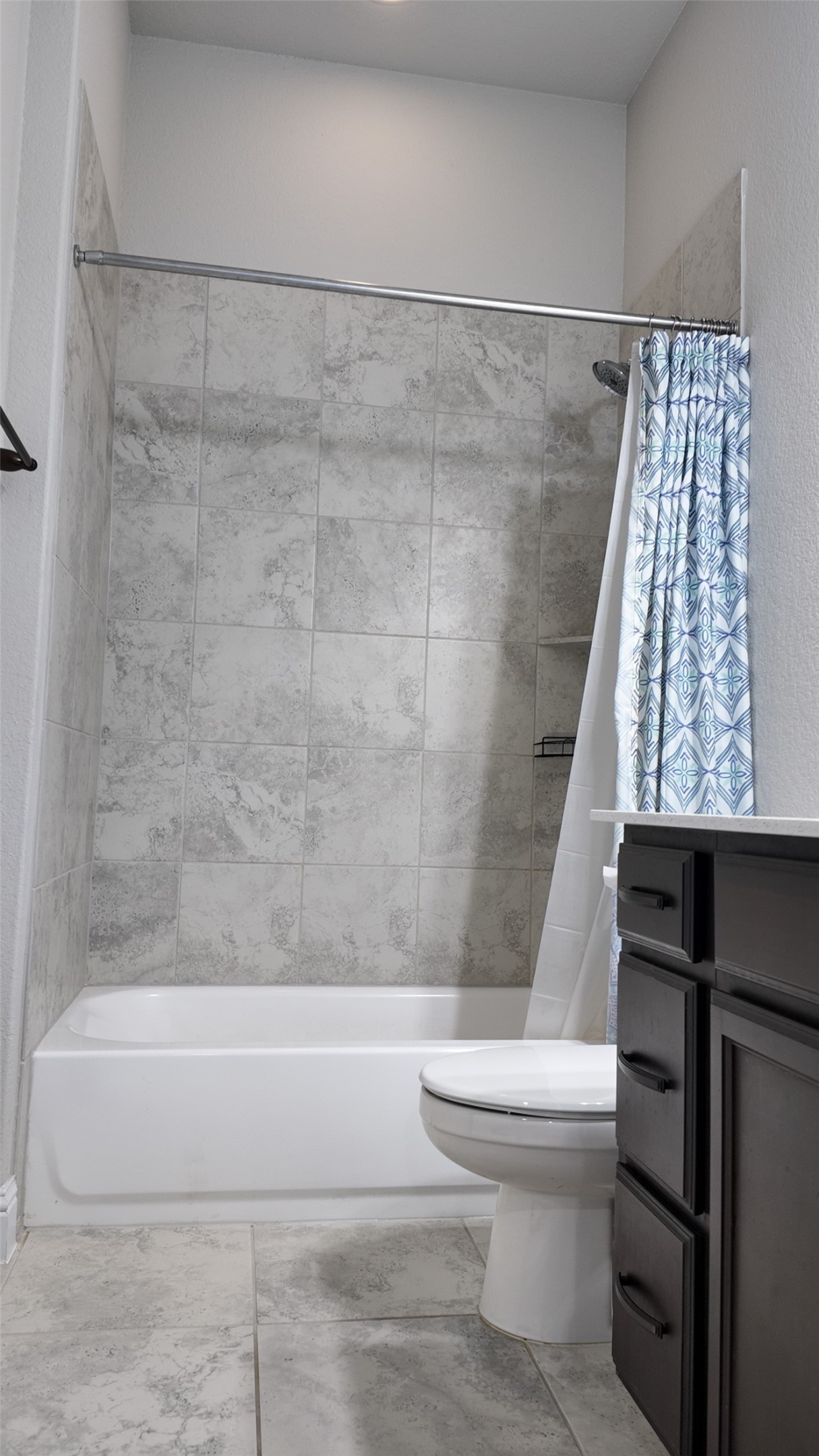 2320 Base Burner Path Leander, TX 78641 - Photo 15 of 24 A well-appointed bathroom features a bathtub with a tiled shower surround and ceramic tile flooring.