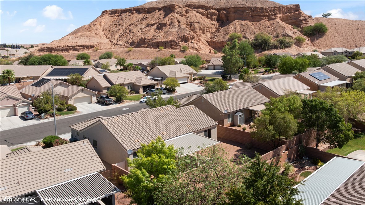874 Glendale Road Mesquite, NV 89027 - Photo 64 of 71 An aerial perspective reveals a residential community nestled against rugged, undulating desert hills.