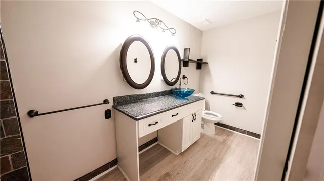 a bathroom with a granite countertop sink and a mirror