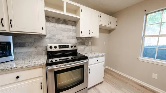 a kitchen with stainless steel appliances white cabinets and a stove