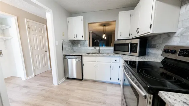 a kitchen with granite countertop a stove sink and cabinets