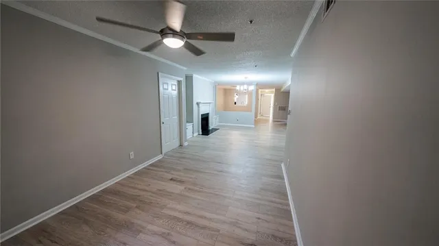 en empty room with wooden floor and ceiling fan