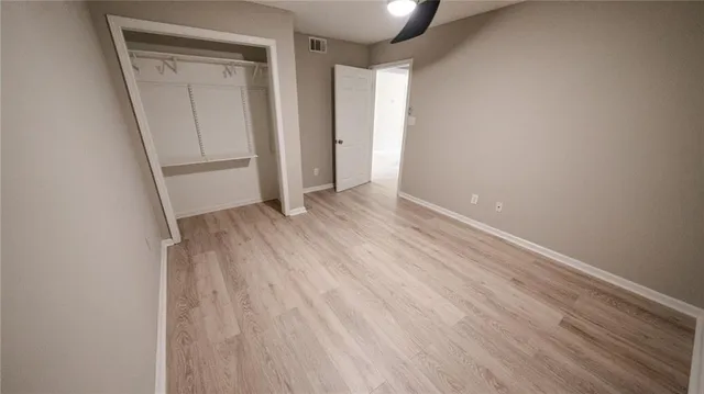 an empty room with wooden floor and entrance