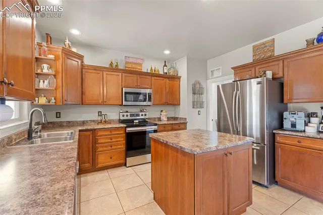 a kitchen with stainless steel appliances granite countertop a sink stove refrigerator and cabinets