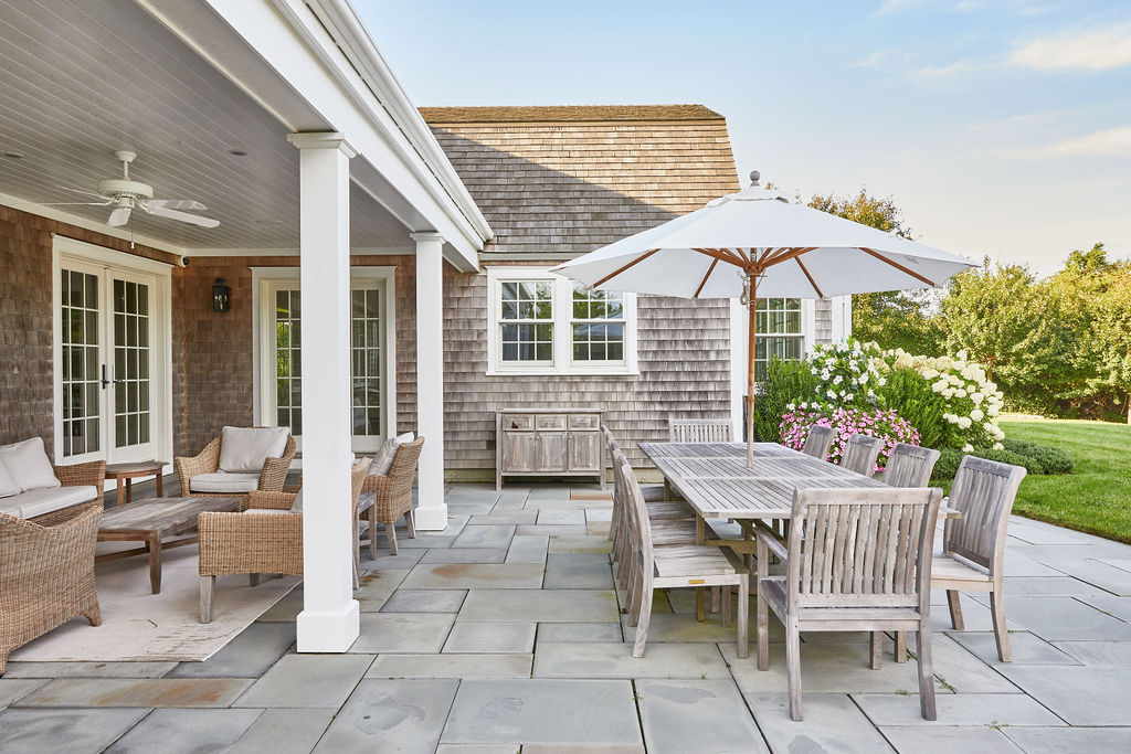 25 Pilgrim Road Nantucket, MA 02554 - Photo 7 of 28 a view of a patio with a table and chairs under an umbrella