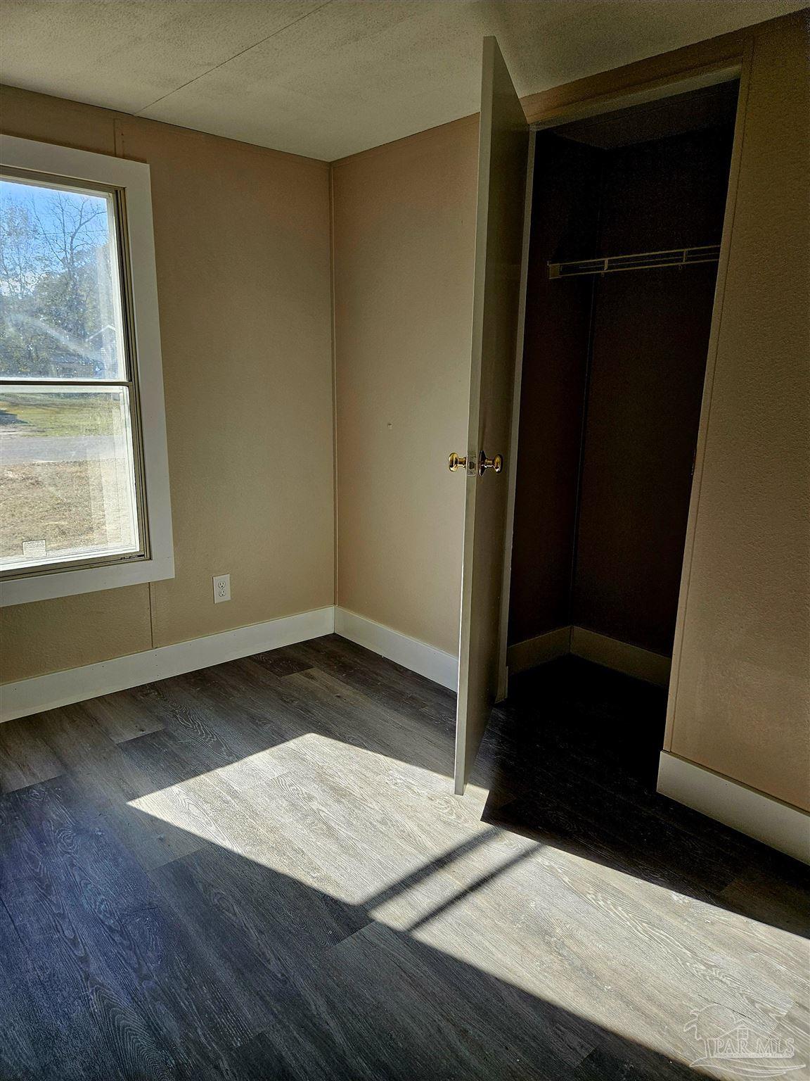 4240 Ewell Street Pace, FL 32571 - Photo 11 of 16 a view of an empty room with wooden floor and a window
