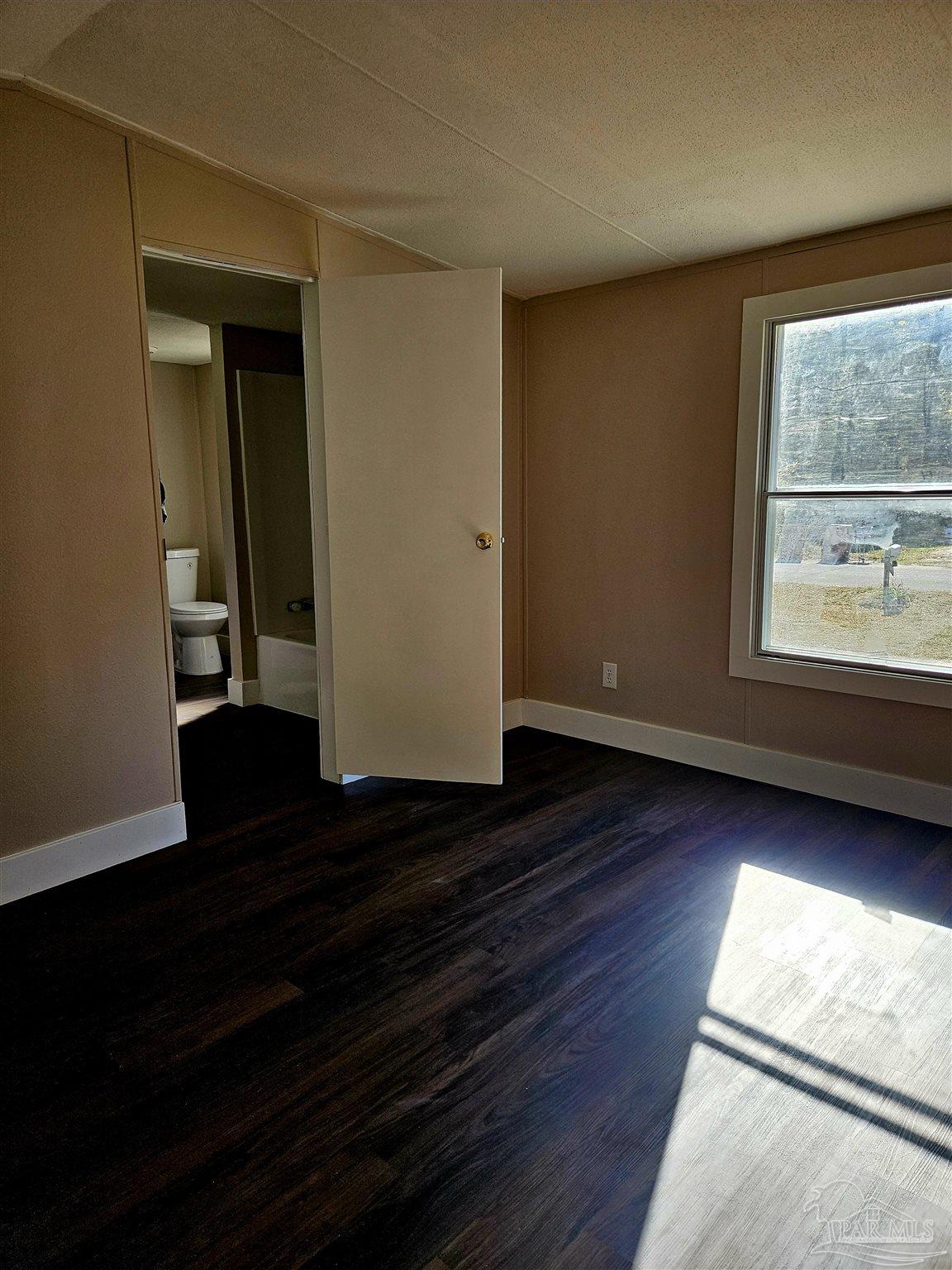 4240 Ewell Street Pace, FL 32571 - Photo 6 of 16 a view of an empty room with wooden floor and a window