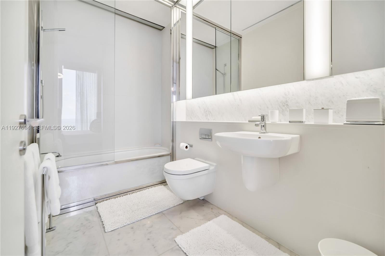 3315 Collins Avenue, Unit 10A Miami Beach, FL 33140 - Photo 43 of 48 a bathroom with a toilet sink and mirror