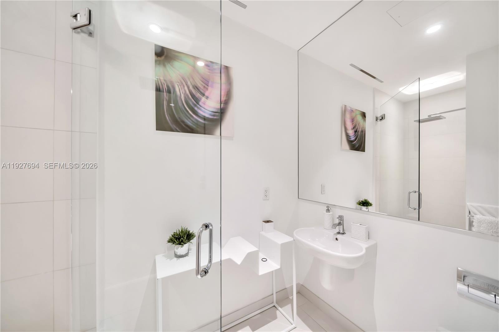 3315 Collins Avenue, Unit 10A Miami Beach, FL 33140 - Photo 45 of 48 a bathroom with a sink a mirror and a shower