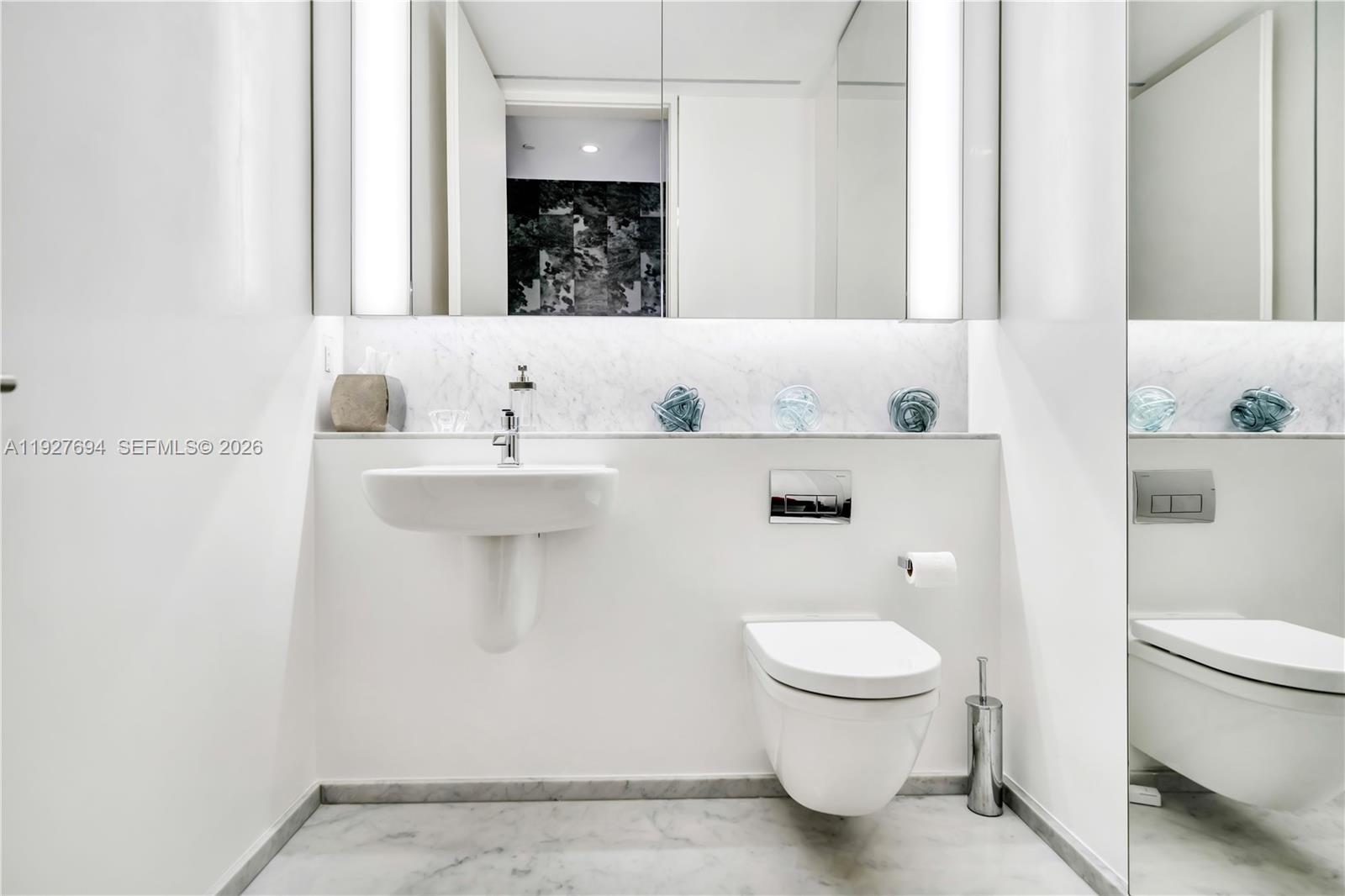 3315 Collins Avenue, Unit 10A Miami Beach, FL 33140 - Photo 46 of 48 a bathroom with a sink a toilet and a mirror