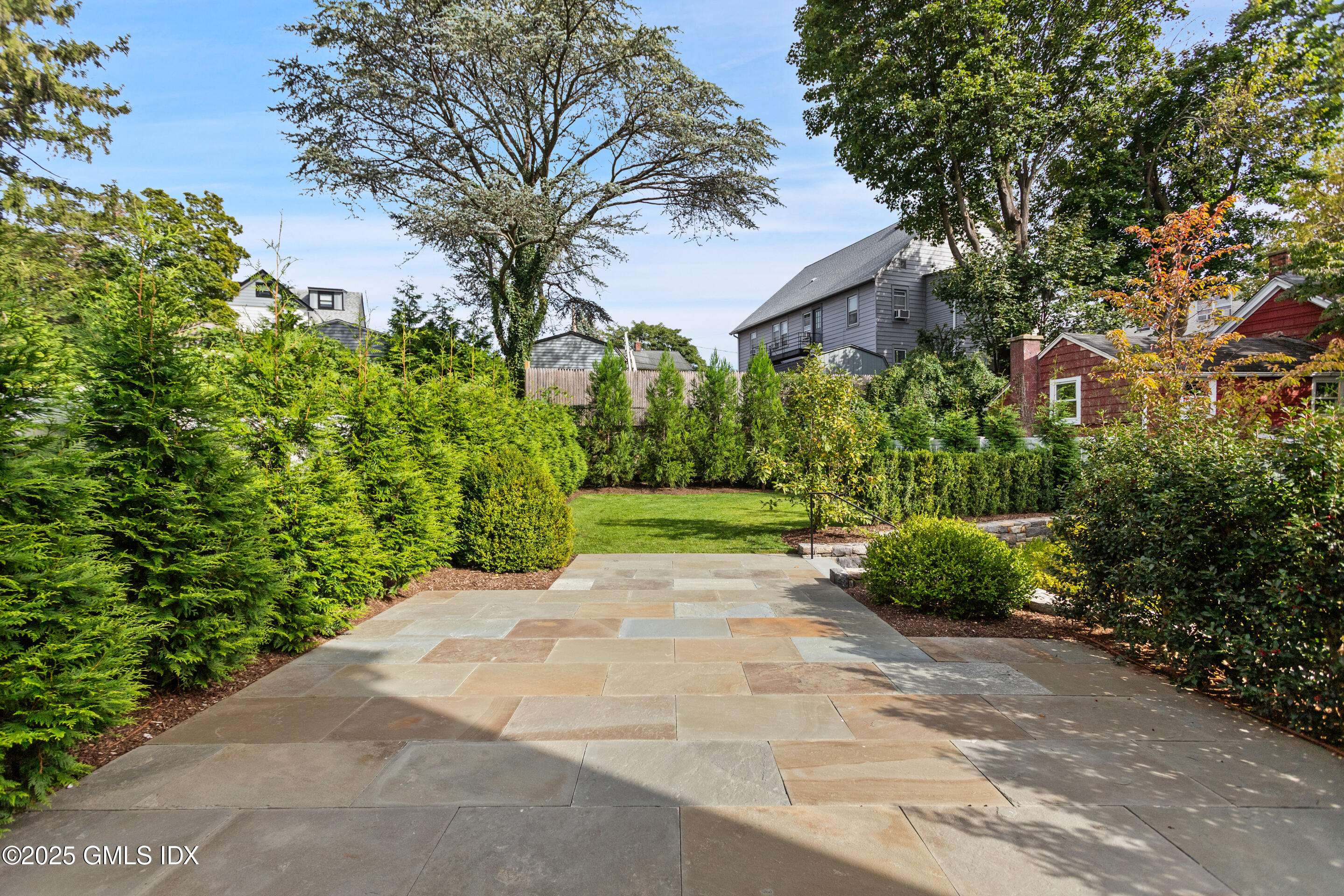 25 Henry Street, Unit B Greenwich, CT 06830 - Photo 3 of 8 a view of a garden with plants and large trees