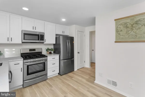 a kitchen with stainless steel appliances a stove a microwave and a refrigerator