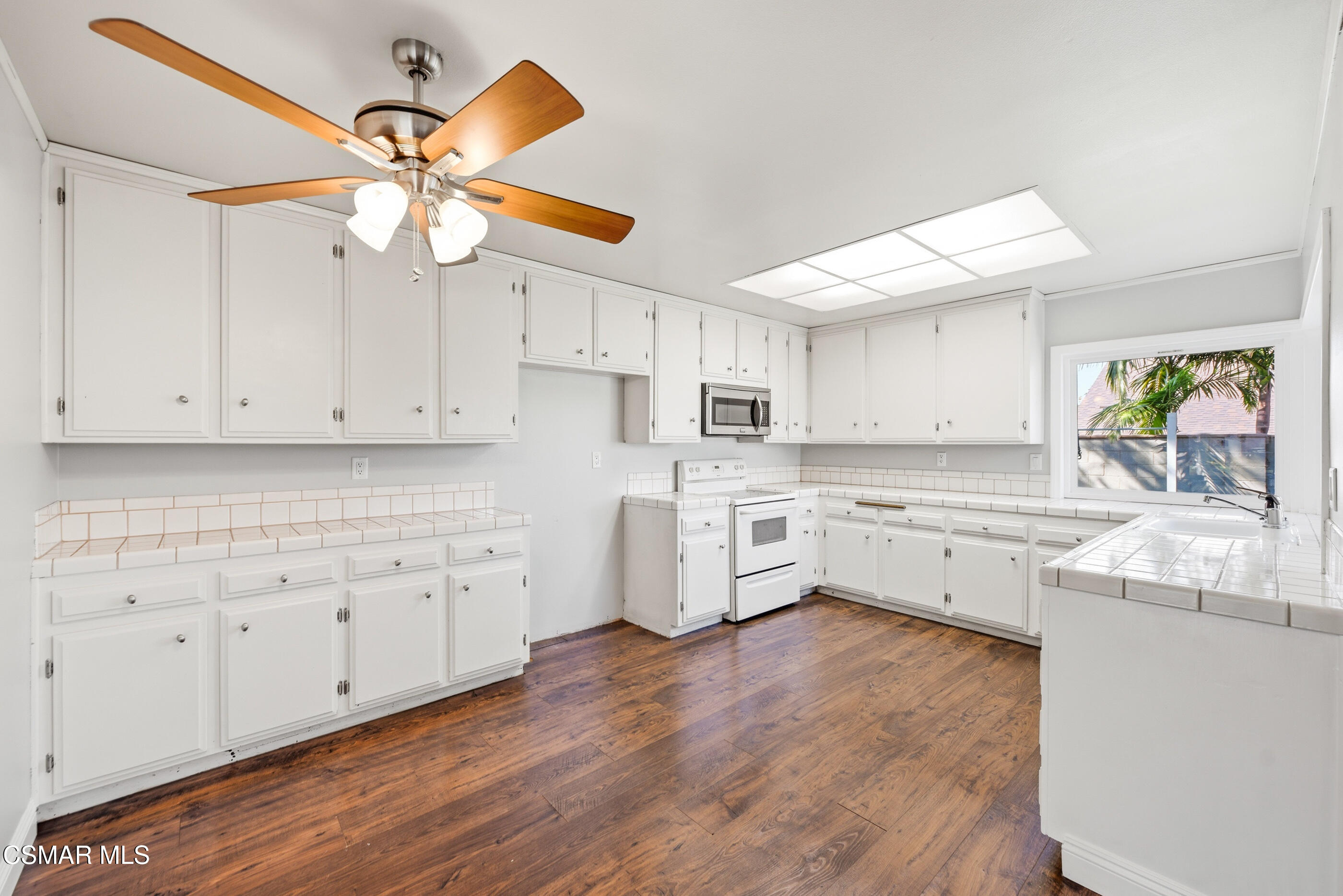 2249 St Clair Avenue Simi Valley, CA 93063 - Photo 20 of 60 a kitchen with stainless steel appliances white cabinets and wooden floors