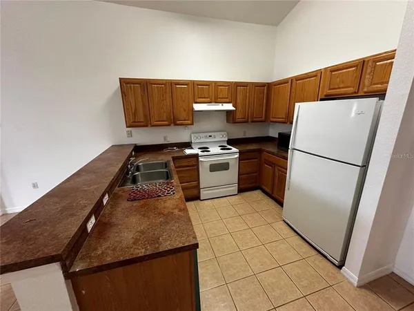 a kitchen with a stove top oven and refrigerator