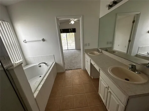 a bathroom with a tub sink and mirror