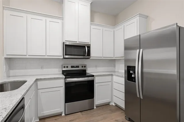 a kitchen with cabinets stainless steel appliances and a sink