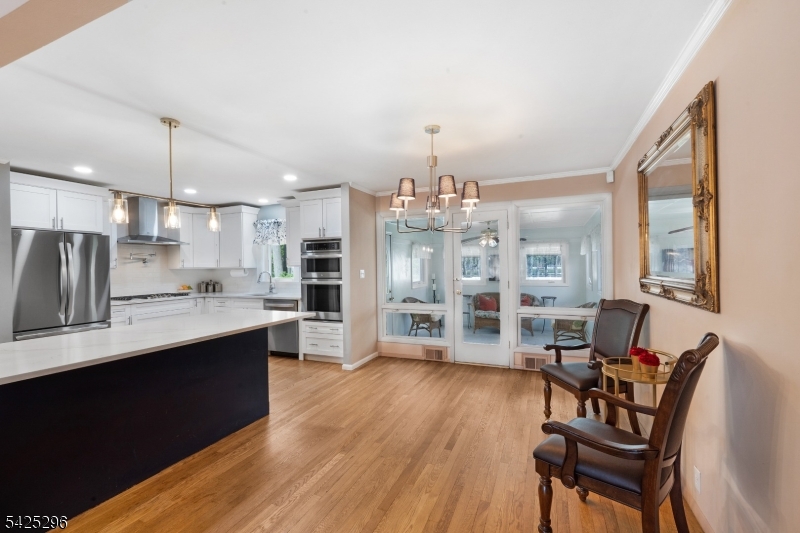 156 Wentz Avenue Springfield, NJ 07081 - Photo 5 of 27 a open kitchen with stainless steel appliances granite countertop a refrigerator a stove a sink dishwasher and a dining table with wooden floor