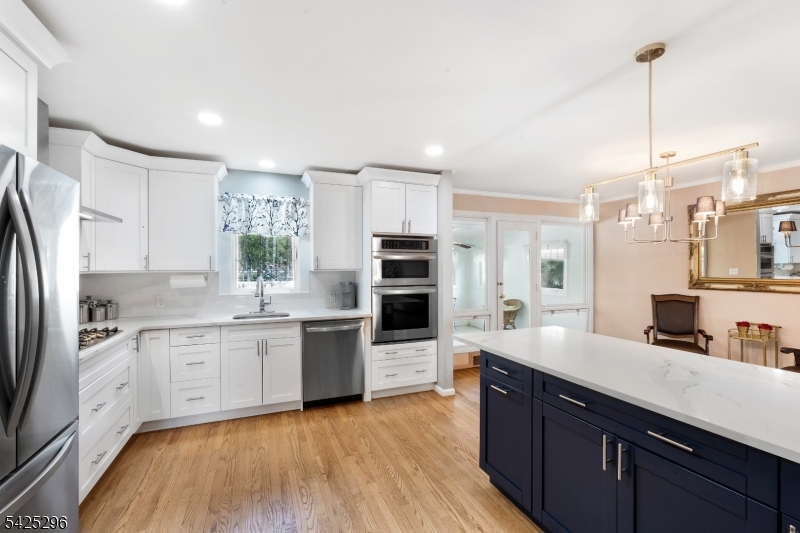 156 Wentz Avenue Springfield, NJ 07081 - Photo 6 of 27 a large kitchen with stainless steel appliances granite countertop a stove refrigerator and a sink with wooden floor