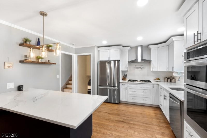 156 Wentz Avenue Springfield, NJ 07081 - Photo 8 of 27 a kitchen with stainless steel appliances kitchen island a sink refrigerator and cabinets