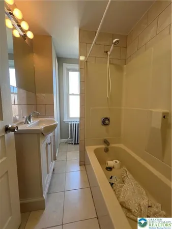 a bathroom with a tub a sink a mirror and a bathtub