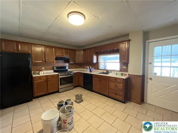 a kitchen with granite countertop a sink cabinets and stainless steel appliances