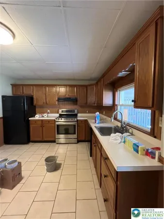 a kitchen with a sink a stove top oven and cabinets
