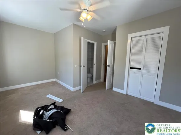 a view of a livingroom with a chandelier fan and a window